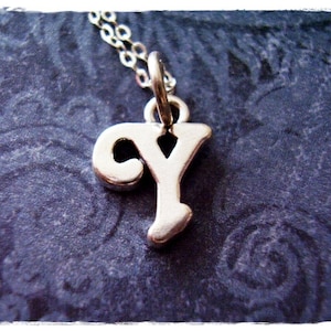 May include: Silver charm necklace with a stylized letter Y pendant.