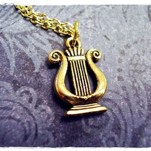 May include: A gold-tone necklace with a lyre pendant. The lyre is a stringed musical instrument from ancient Greece.