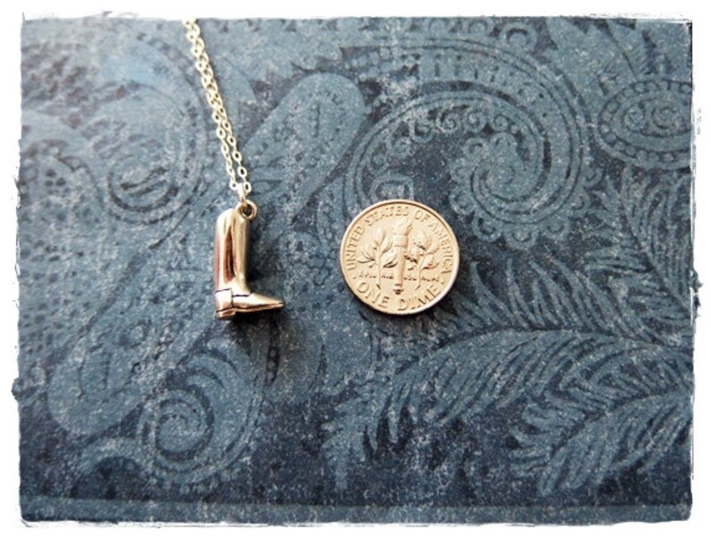 May include: A gold necklace with a boot charm. The boot is about the size of a dime.