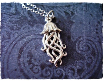 May include: A silver pendant necklace featuring a detailed, intricate design of a stylized jellyfish with flowing tentacles.