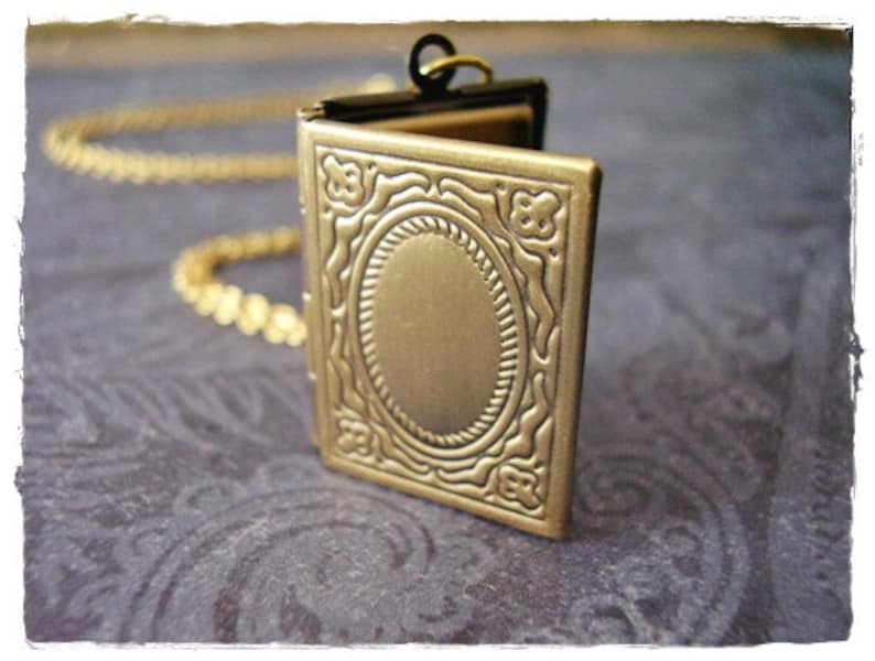 Peut inclure: Un collier avec un m&eacute;daillon en or orn&eacute;. Le m&eacute;daillon est ouvert et pr&eacute;sente un espace ovale vide &agrave; l'int&eacute;rieur.