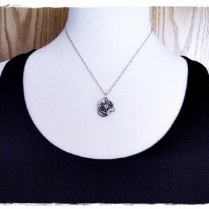 May include: A silver necklace with a flower pendant. The flower pendant has a detailed design and is made of metal.
