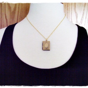 Peut inclure: Un collier en cha&icirc;ne dor&eacute;e avec un petit pendentif de m&eacute;daillon orn&eacute;. Le m&eacute;daillon est ferm&eacute; et pr&eacute;sente un design d&eacute;taill&eacute;.