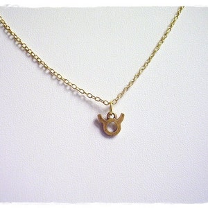 May include: A gold chain necklace with a small gold Taurus zodiac sign pendant.