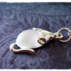 May include: A silver cat charm necklace with a frosted glass cat head pendant.