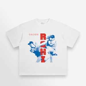 May include: White t-shirt featuring a blue and red graphic of a baseball player in action. The word "ROSHI" is vertically printed in red, with Japanese text above the graphic.
