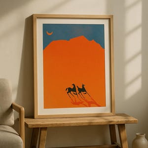 May include: Framed art print featuring a minimalist desert landscape. The artwork depicts two stylized black animals with long shadows against an orange background, with a blue sky and a crescent moon. The print is in a light wood frame.