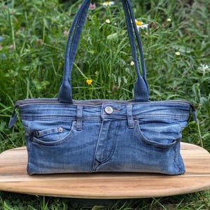 Upcycled denim slouch shoulder bag with polka dot lining.