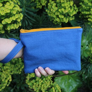 Bolso de mano reciclado azul aciano. Con cremallera amarilla y forrado con estampado animal marino: cebra, elefante, flamenco, canguro y rinoceronte.