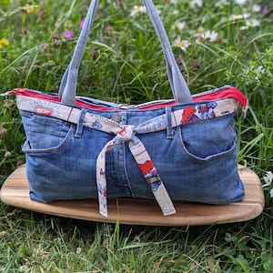 Upcycled denim large slouch bag with zip and pockets. Day of the dead skeleton lining.