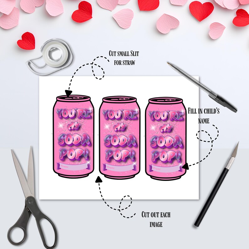 Op de afbeelding: Drie roze frisdrankblikjes met de tekst "YOU'RE my SODA POP!" worden weergegeven op een witte achtergrond. De afbeelding bevat een schaar, een pen, een hobbymes, tape en papieren hartjes.