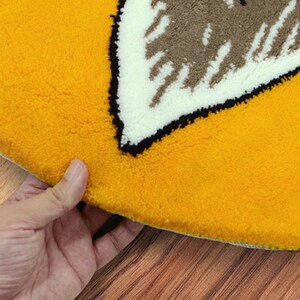 May include: A yellow round rug with a white and brown geometric design in the center.