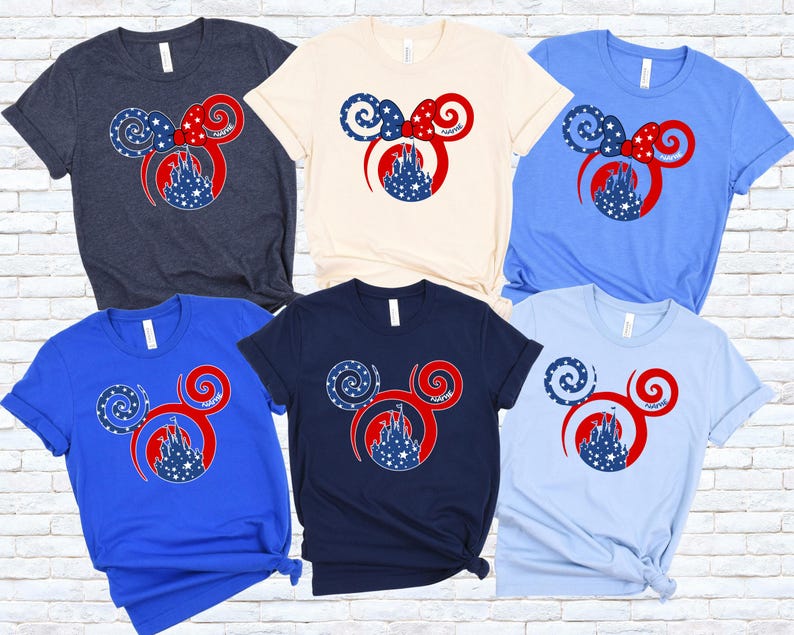 May include: A collection of six short-sleeved t-shirts in various colors, including navy, cream, blue, and light blue. Each shirt features a red, white, and blue graphic of Mickey Mouse ears with a castle silhouette.
