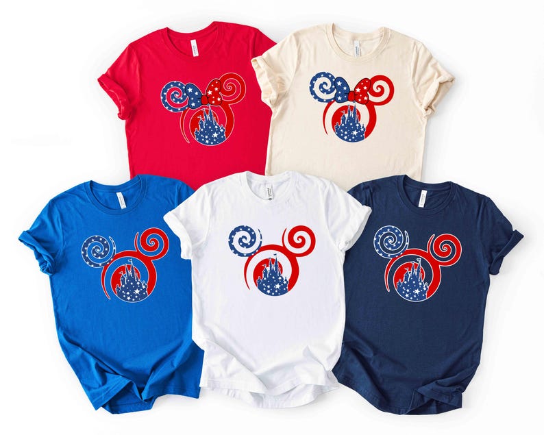 May include: Five short-sleeved t-shirts in red, blue, white, cream, and navy. Each shirt features a red Mickey Mouse head design with a patriotic theme, including a castle and star-filled accents.