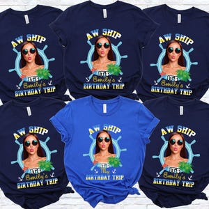 May include: A collection of navy blue and blue t-shirts. Each shirt features a graphic with the text "AW SHIP", a woman wearing sunglasses, a ship's wheel, and the text "It's Emily's Birthday Trip".