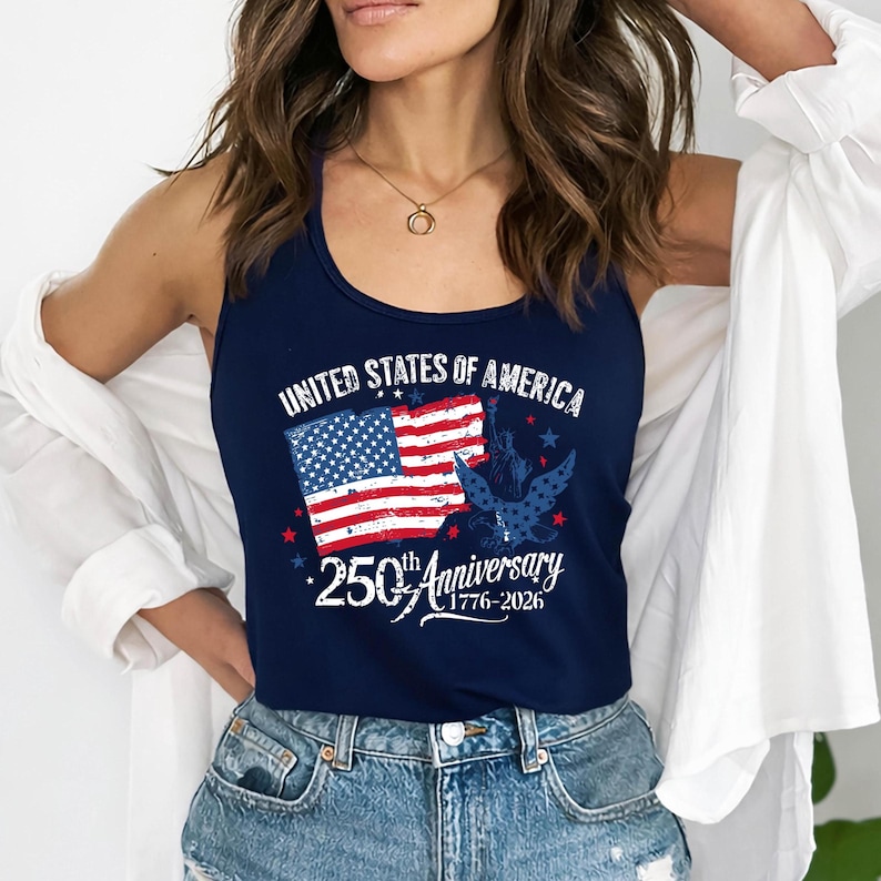 May include: A navy blue vest top with a patriotic design. The top features the text "UNITED STATES OF AMERICA" above a stylized American flag and an eagle graphic. Below, it reads "250th Anniversary 1776-2026".