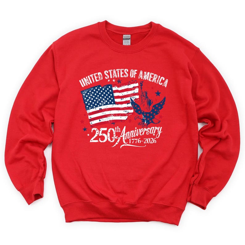May include: A red sweatshirt featuring a graphic celebrating the 250th anniversary of the United States. The design includes the American flag, an eagle, and the Statue of Liberty, with the text "United States of America" and "250th Anniversary 1776-2026."