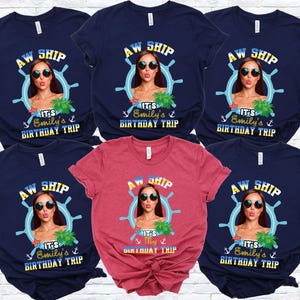 May include: Navy blue and red t-shirts with a graphic featuring a woman in sunglasses, a ship's wheel, and the text "AW SHIP, It's Emily's Birthday Trip." The shirts are short-sleeved and suitable for a birthday celebration.