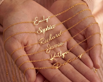 May include: Gold-colored name necklaces spelling out "Emily", "Sophia", "Richard", "Jamie", "Kaitlyn", and "Destiny". The necklaces are displayed on a person's open hands. The necklaces are on delicate chains.