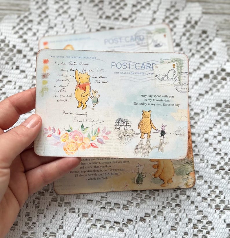 May include: Two Winnie the Pooh postcards featuring illustrations of Winnie the Pooh and Piglet. The text on the postcards reads "Any day spent with you is my favourite day. So, today is my new favourite day." and "Something you must always remember...than you believe, stronger than you seem, and smarter than you think...the most important thing is, even if we're apart, I'll always be with you." - A.A. Milne Winnie the Pooh