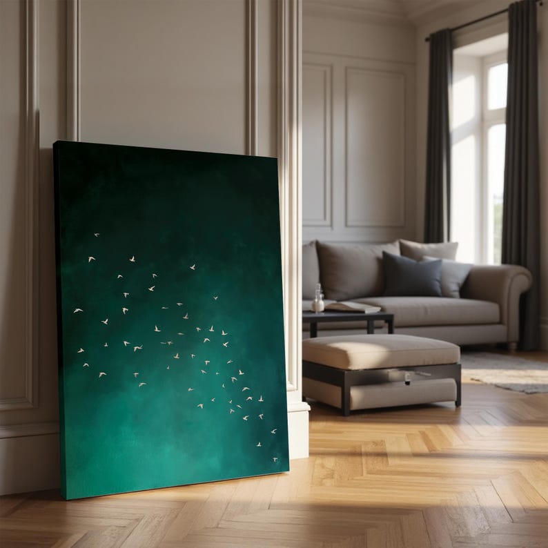 May include: A large canvas art print featuring a dark teal and green gradient background with a flock of white birds in flight. The artwork is leaning against a white wall in a well-lit room with a sofa and ottoman.
