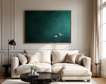 May include: A living room scene featuring a cream-colored sectional sofa, a round black marble coffee table, and a large framed artwork. The artwork depicts two white birds against a dark teal background. The room has a neutral color palette.