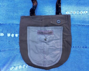 May include: A brown and gray canvas tote bag with a large zippered pocket and a smaller pocket with a button closure. The bag has a paisley patterned strap.