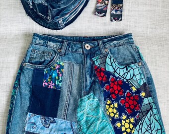 May include: A denim skirt, bucket hat, and earrings set. The skirt features patchwork with floral and patterned fabric accents. The hat and earrings are also made from denim and fabric scraps. The set is a unique, handmade fashion statement.