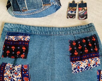May include: A denim skirt, bucket hat, and earrings set. The skirt has decorative patches with floral and geometric patterns. The bucket hat and earrings are made from denim scraps. The set is a unique, handmade fashion statement.