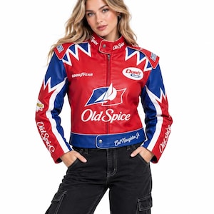Könnte beinhalten: Eine rot-weiß-blaue Rennjacke mit Old Spice-Branding, einem Dennit Racing-Logo und Goodyear-Schriftzug. Die Jacke verfügt über einen Stehkragen, einen Frontreißverschluss und den in Weiß auf den blauen Saum gedruckten Namen Cal Naughton Jr.
