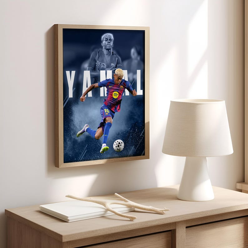 K&ouml;nnte beinhalten: Gerahmtes Poster mit einem Fu&szlig;ballspieler in blau-roter Uniform, der einen Fu&szlig;ball tritt. Der Name des Spielers, YAMAL, ist in gro&szlig;en wei&szlig;en Buchstaben dargestellt. Der Hintergrund hat einen blau-wei&szlig;en Raucheffekt.