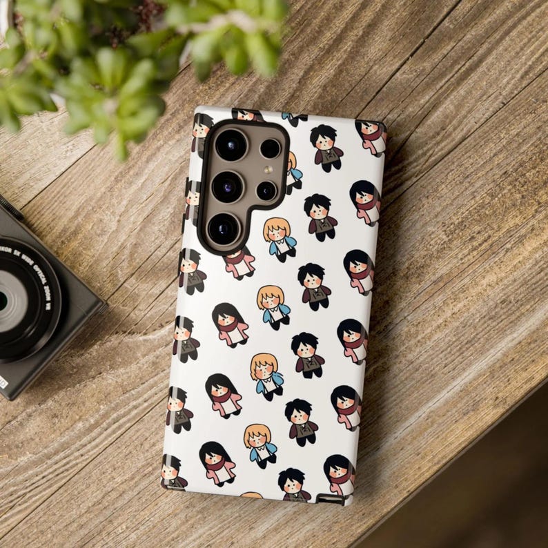 Peut inclure: Coque de t&eacute;l&eacute;phone blanche avec un motif r&eacute;p&eacute;t&eacute; de personnages de dessins anim&eacute;s en diff&eacute;rentes tenues. Les personnages ont diff&eacute;rentes couleurs de cheveux et portent des tenues dans les tons marron, bleu et rose. La coque de t&eacute;l&eacute;phone poss&egrave;de un module cam&eacute;ra avec plusieurs lentilles.