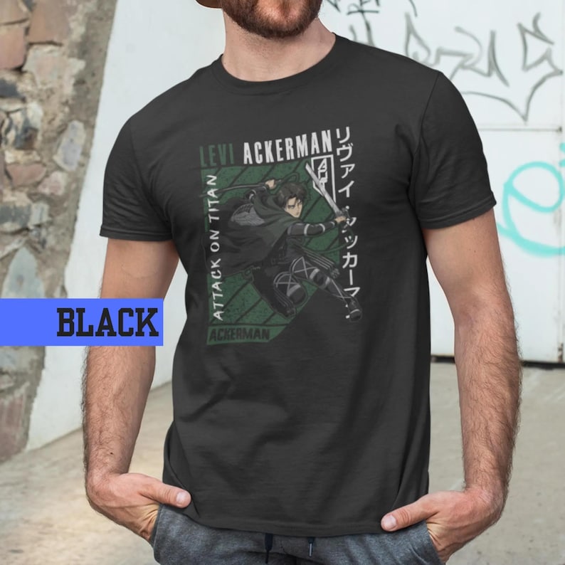 May include: Black t-shirt featuring a graphic of Levi Ackerman from "Attack on Titan." The design includes text in English and Japanese, with a green geometric background. The word "BLACK" is in a blue rectangle.