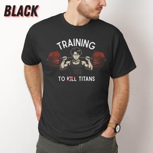 K&ouml;nnte beinhalten: Schwarzes T-Shirt mit einer Grafik eines muskul&ouml;sen Charakters, der Gewichte hebt, mit dem wei&szlig;en Text "TRAINING TO KILL TITANS". Das Wort "BLACK" befindet sich in der oberen linken Ecke.
