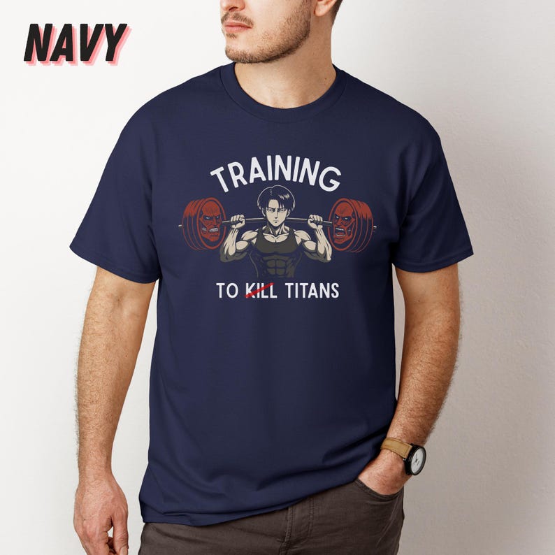K&ouml;nnte beinhalten: Marineblaues T-Shirt mit dem Text "TRAINING TO KILL TITANS" und einer Illustration einer Figur, die Gewichte hebt. Das Wort "NAVY" ist in der oberen linken Ecke aufgedruckt.