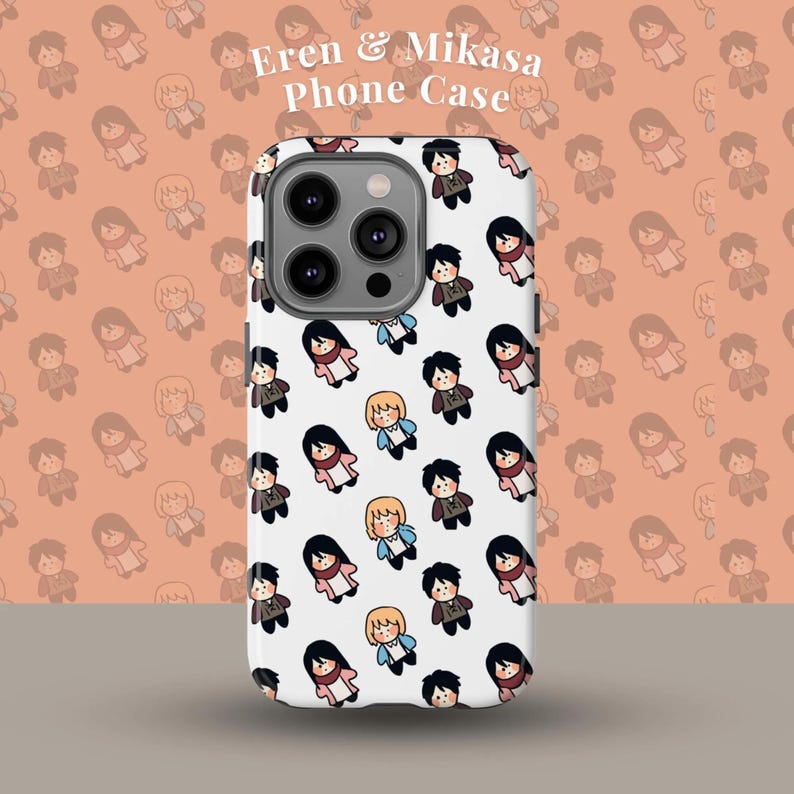 May include: A white phone case with a repeating pattern of cartoon characters. The case has a camera cutout and the text "Eren & Mikasa Phone Case" is visible. The background is a peach colour with a repeating pattern of the same cartoon characters.