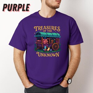 May include: Purple t-shirt with the text "Treasures of the Unknown" and a graphic of a pig in a wagon. The wagon has a green roof and a wooden wheel. The shirt also has the word "Purple" in the upper left corner.