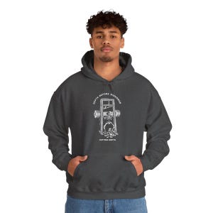 Puede incluir: Sudadera con capucha gris oscuro con bolsillo delantero y cord&oacute;n. El gr&aacute;fico en la parte delantera presenta un esqueleto en una guillotina con las palabras "DEPTH BEFORE DISHONOR" y "CUTTING DEPTH" en un dise&ntilde;o circular.