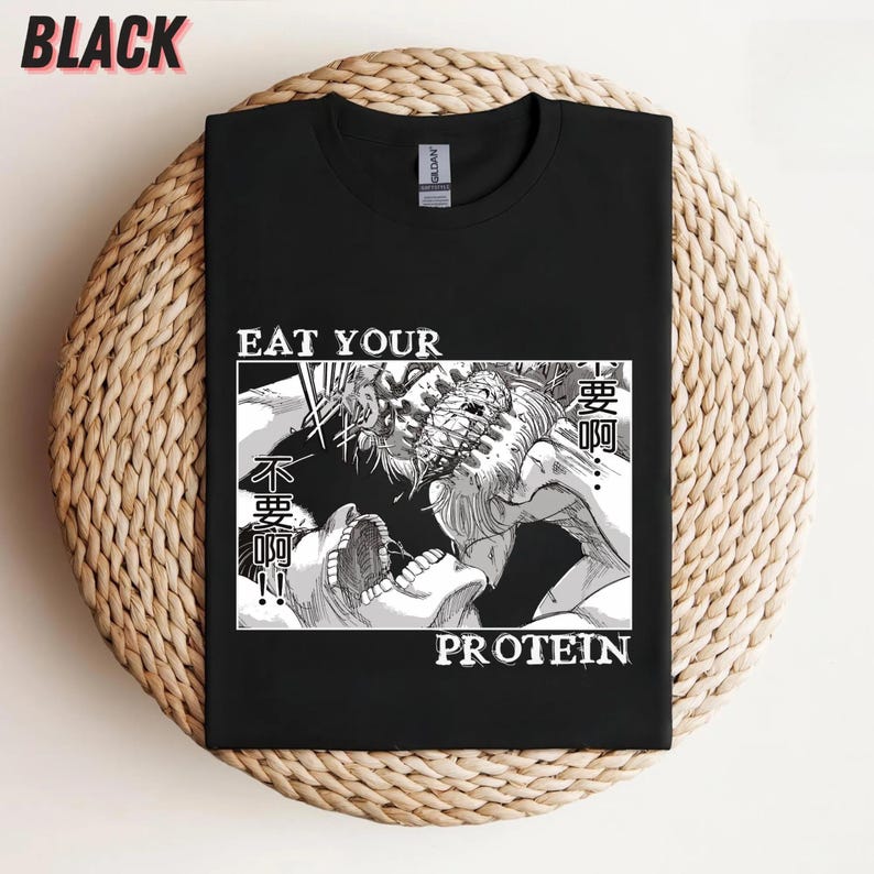 May include: Black t-shirt with a graphic design featuring a manga-style illustration of two figures in a battle scene. The text "EAT YOUR PROTEIN" is printed in white.