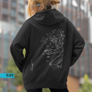 May include: Black hoodie featuring a white graphic of a figure with a detailed outline on the back. The hoodie has a drawstring hood and a kangaroo pocket. The word "BLACK" is printed in a blue rectangle on the bottom left.