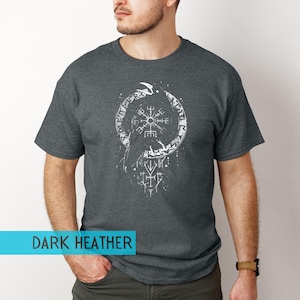 K&ouml;nnte beinhalten: Dunkelgraues meliertes T-Shirt mit wei&szlig;em Grafikdesign. Das Design zeigt ein kreisf&ouml;rmiges Muster mit Runen und einem zentralen Symbol sowie den Text "DARK HEATHER". Das T-Shirt hat kurze &Auml;rmel und einen Rundhalsausschnitt.