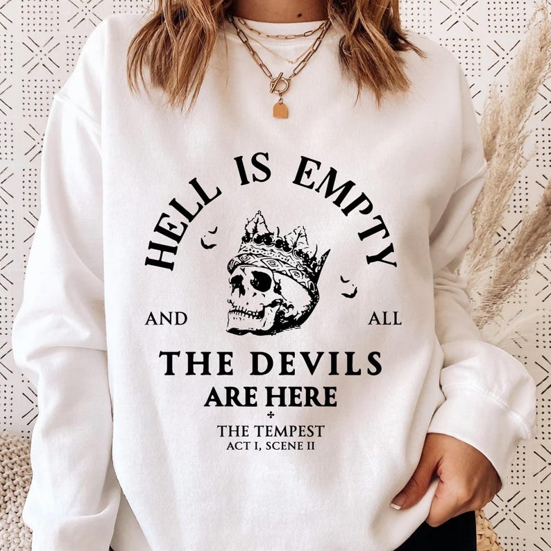May include: White sweatshirt with a black graphic. The design includes a crowned skull and the text "HELL IS EMPTY AND ALL THE DEVILS ARE HERE", referencing The Tempest.