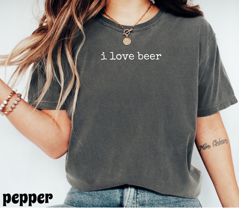 May include: A dark gray t-shirt with the text "i love beer" in white. The shirt is a casual style, likely made of cotton, and has a relaxed fit. The word "pepper" is at the bottom of the image.