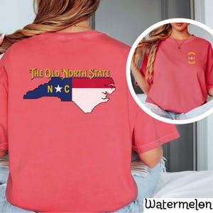 May include: A red t-shirt with a graphic of the state of North Carolina and the text "The Old North State" and "N*C".