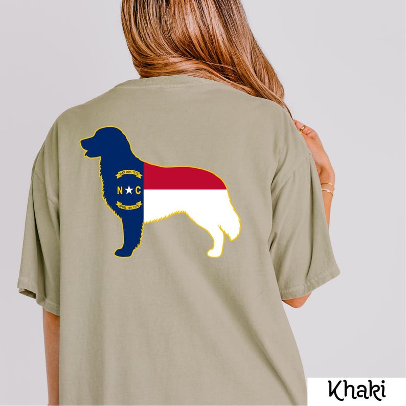 Puede incluir: Camiseta color caqui con la silueta de un perro que incorpora el dise&ntilde;o de la bandera del estado de Carolina del Norte. La cabeza y el frente del perro son azules, el centro es rojo y la parte trasera es blanca. El texto "Khaki" est&aacute; en la parte inferior derecha.