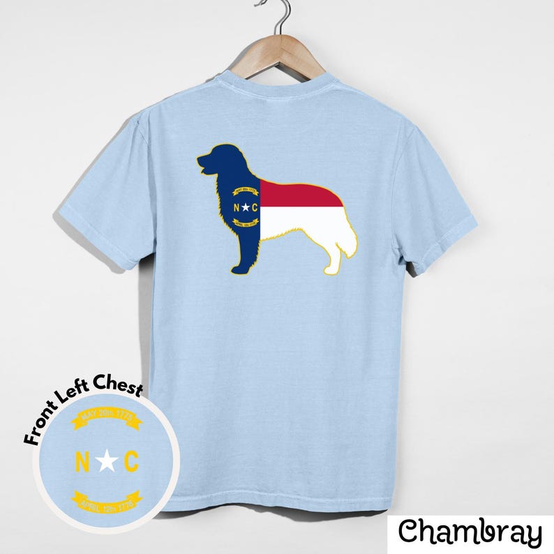 Puede incluir: Camiseta azul claro con un gr&aacute;fico de silueta de perro, que incorpora el dise&ntilde;o de la bandera del estado de Carolina del Norte. La camiseta tambi&eacute;n tiene un dise&ntilde;o en el pecho izquierdo con el texto "N C". La palabra "Chambray" est&aacute; impresa en la parte inferior derecha.