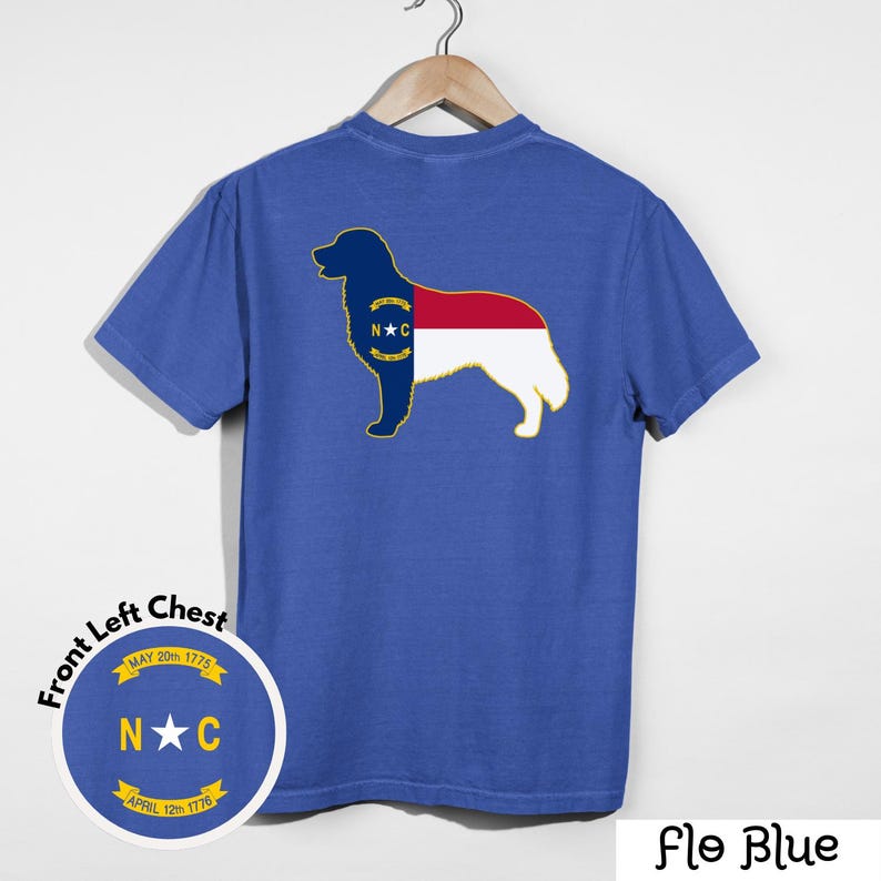Puede incluir: Una camiseta azul con un gr&aacute;fico de la silueta de un perro relleno con el dise&ntilde;o de la bandera del estado de Carolina del Norte. La camiseta tambi&eacute;n presenta un gr&aacute;fico circular en el pecho izquierdo delantero con texto y las iniciales del estado. El texto "Flo Blue" est&aacute; en la parte inferior.