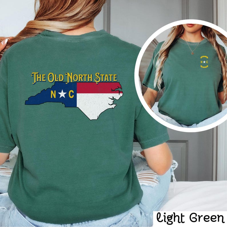 May include: A light green t-shirt with a graphic of the state of North Carolina and the text "The Old North State" and "N*C".