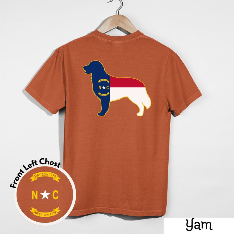 Puede incluir: Camiseta naranja quemado con una silueta de perro y el dise&ntilde;o de la bandera del estado de Carolina del Norte en la espalda. El pecho izquierdo tiene un emblema circular con el texto "N C" y "MAY 20th 1775" y "APRIL 12th 1776".