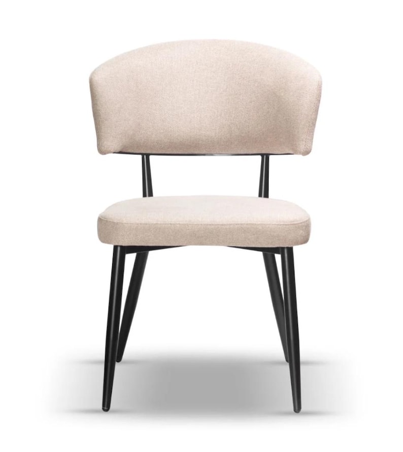 May include: A beige upholstered dining chair with a curved back and black metal legs.
